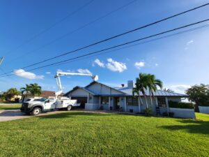 A worker in a boom lift inspecting a chimney on a house for SWFL Chimney Caps Inc. in Fort Myers, FL.