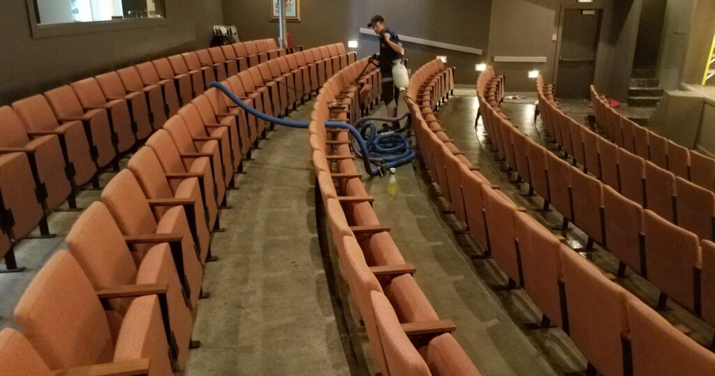 A professional worker cleaning the carpet in a large auditorium for Royal Carpet & Upholstery Cleaning in Lincoln, NE.