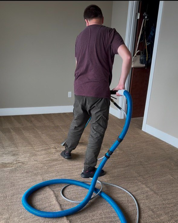 A worker actively cleaning a carpet with a professional cleaning wand by Alex & Mary Carpet & Upholstery Cleaning in Tacoma, WA.
