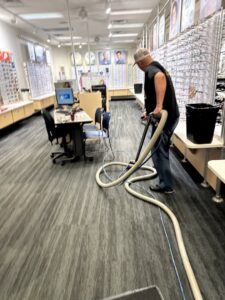 A worker professionally cleaning commercial carpet with a specialized wand for Super Duper Carpet & Duct Cleaning in Pittsburgh, PA.
