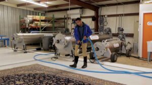 A worker operating a professional rug cleaning machine at Advanced Cleaning Systems in Atlanta, GA.