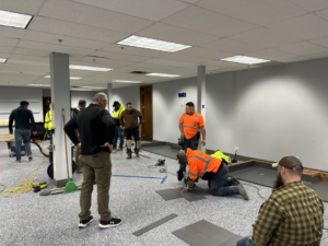 A professional worker kneeling and precisely cutting flooring tiles during an installation by Hank's Specialties, Inc. in Saint Paul, MN.