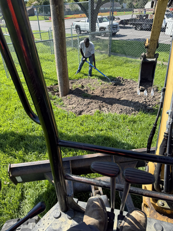 A worker from Relay Electric, LLC raking dirt around the base of a newly installed utility pole in Suffolk, VA.