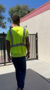 A worker in a high-visibility vest inspecting a newly installed metal gate by San Diego Fencing Contractor A's Pro Build Fencing in San Diego, CA.
