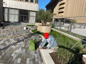 A worker installing artificial turf for an outdoor area by Carpet World Baton Rouge, LA.