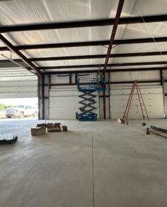 Worker on a scissor lift installing commercial garage doors for Mr. Garage Door in Bell Gardens, CA.