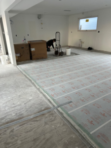 A worker installing a radiant floor heating system for Carbonic Heat LLC in Lake Hopatcong, NJ