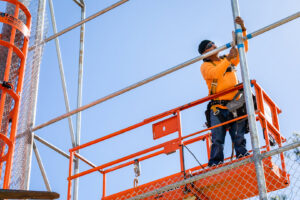 A worker on a lift installing a tall chain-link fence for Upright Fencing Hawaii LLC in Kapolei, HI.