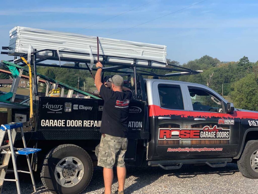 A worker loading garage door panels onto a service truck for Rose Quality Garage Doors in Murfreesboro, TN