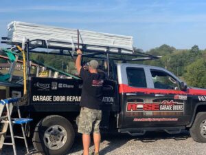 A worker loading garage door panels onto a service truck for Rose Quality Garage Doors in Murfreesboro, TN