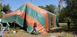 A worker walking near a residential house covered in a fumigation tent by Rivers Pest Control Service, Inc. in Jacksonville, FL
