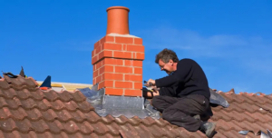 A worker repairing chimney flashing on a roof for Denver Chimney Sweep in Denver, CO.