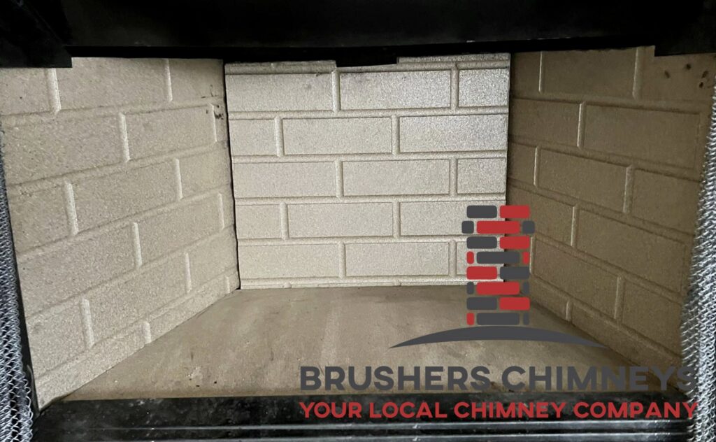A Brushers Chimneys worker on a ladder repairing the siding of a chimney in Houston, TX.