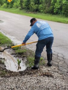 A worker from R & W Lawn care service LLC shoveling debris during a yard cleanup in Tulsa, OK.