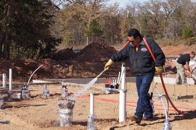 A Reliable Termite of OKC worker performing pest treatment at a new construction site in Oklahoma City, OK.