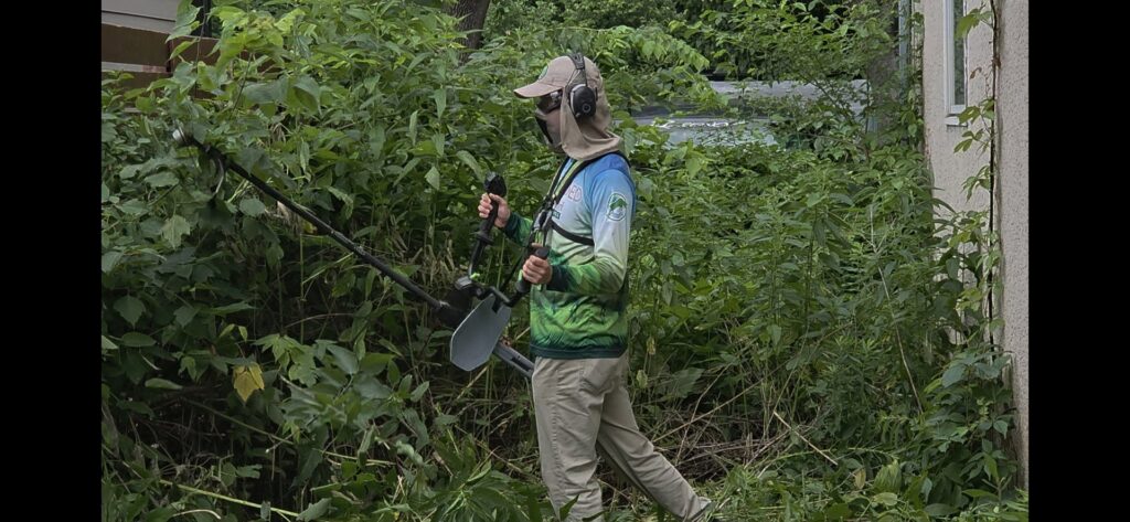 A Grounded Earth worker using a brush cutter to clear an overgrown yard in Minneapolis, MN.