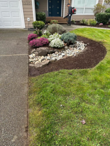 A worker using a leaf blower to clear a driveway, showcasing services by Martin's Landscaping CO. in Renton, WA.