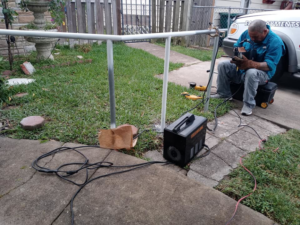 A worker welding an installed metal fence or railing for Morin Fencing in Corpus Christi, TX.