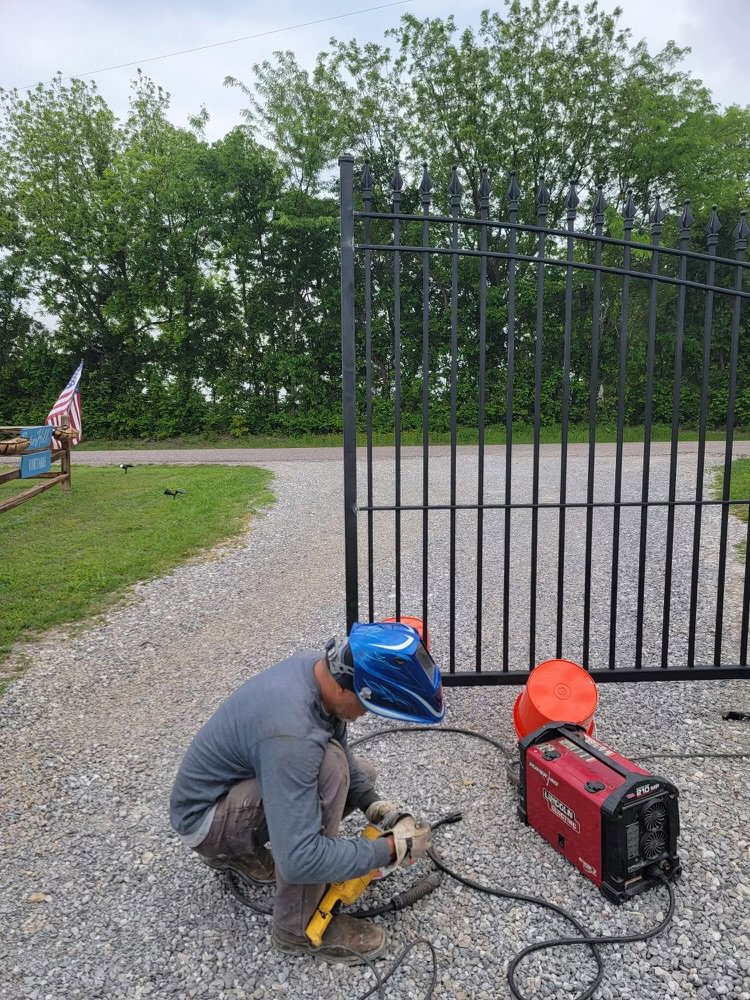 A worker welding a metal gate during installation by HDR Systems Gate, Fence & Garage doors in Plano, TX