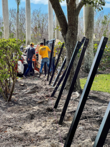 Workers installing black fence posts for a new fence project by Nash Fence & Supplies Inc. in Lake Charles, LA.