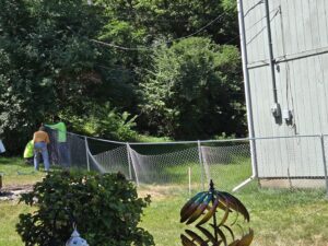 Workers installing a new chain-link fence, demonstrating services by Sergio's Fence in Kansas City, KS.