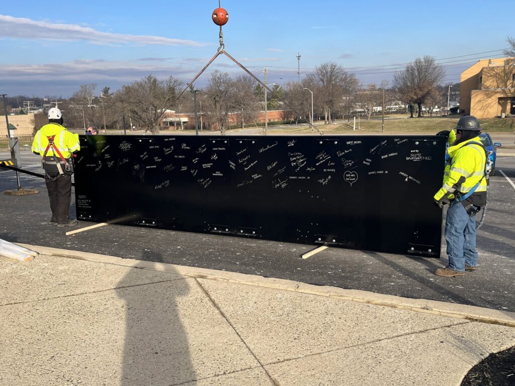 Workers in safety gear installing a large electrical panel with a crane for IBEW Local 24 Membership Development in Baltimore, MD.