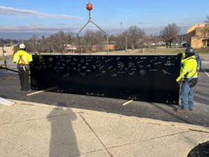 Workers in safety gear installing a large electrical panel with a crane for IBEW Local 24 Membership Development in Baltimore, MD.