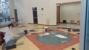 Workers installing patterned commercial flooring in a large space for Carpets Texas in El Paso, TX.