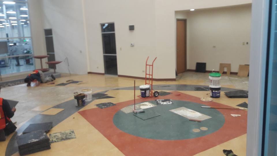 Workers installing patterned commercial flooring in a large space for Carpets Texas in El Paso, TX.