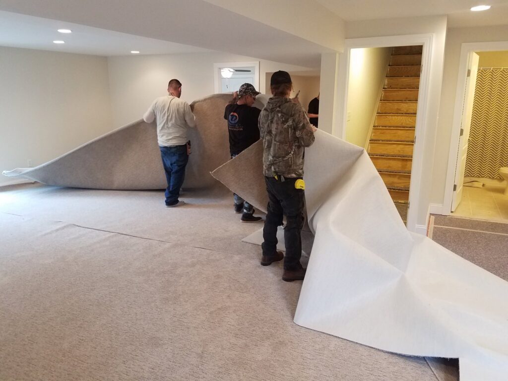 Workers installing light-colored wall-to-wall carpet in a room for Danny's Flooring Service LLC in White Plains, MD