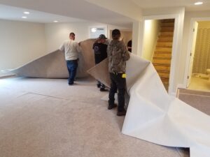 Workers installing light-colored wall-to-wall carpet in a room for Danny's Flooring Service LLC in White Plains, MD