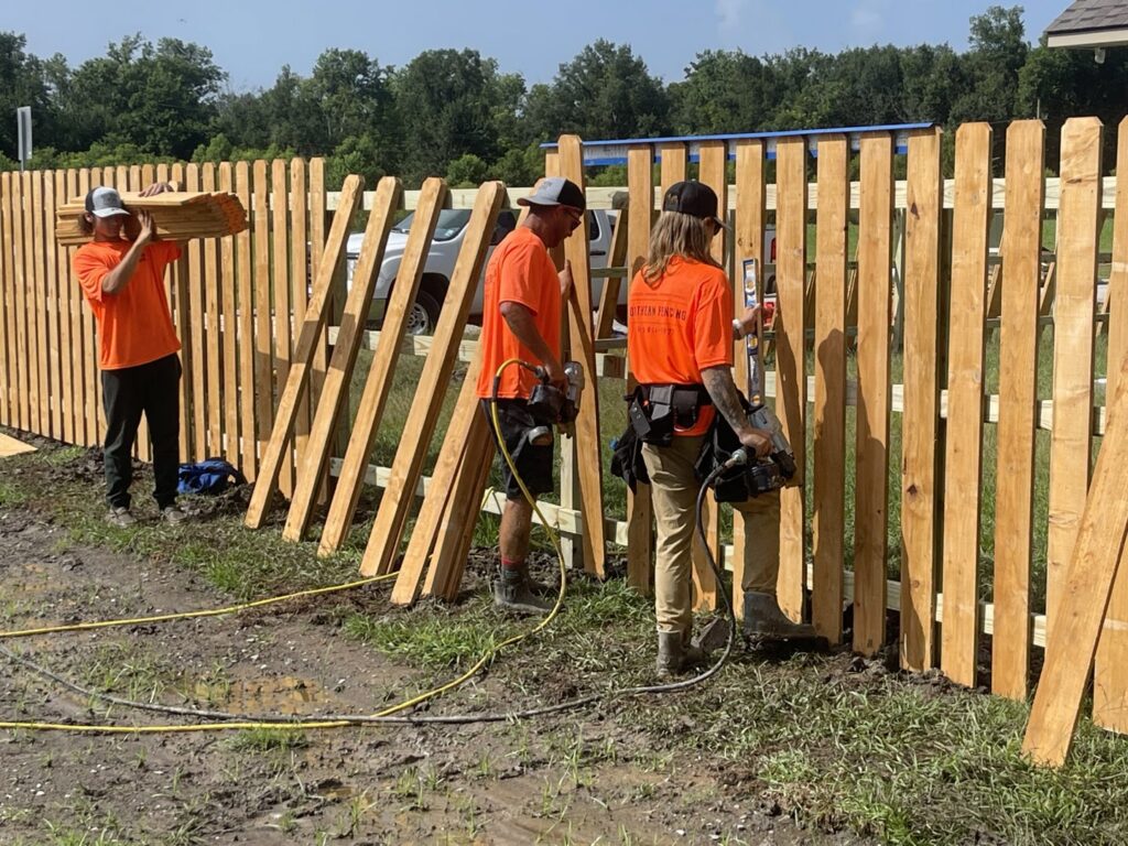 Southern Fencing, LLC workers installing wood fence pickets on a new fence project in Houma, LA.