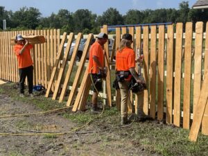 Southern Fencing, LLC workers installing wood fence pickets on a new fence project in Houma, LA.