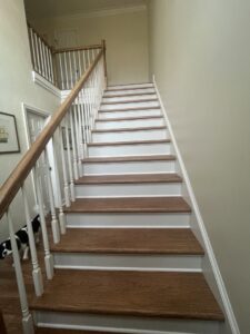 Floors To Go workers carefully unloading a large carpet roll from a delivery truck at a residential property in Virginia Beach, VA.
