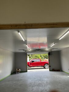 A workshop interior with bright fluorescent strip lights on the ceiling, showcasing electrical work by Superior Electrical Solutions llc in Clear Spring, MD.