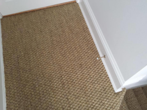 Close-up of a neatly installed woven carpet in a hallway by Karpet Klinic Inc. in Cranston, RI