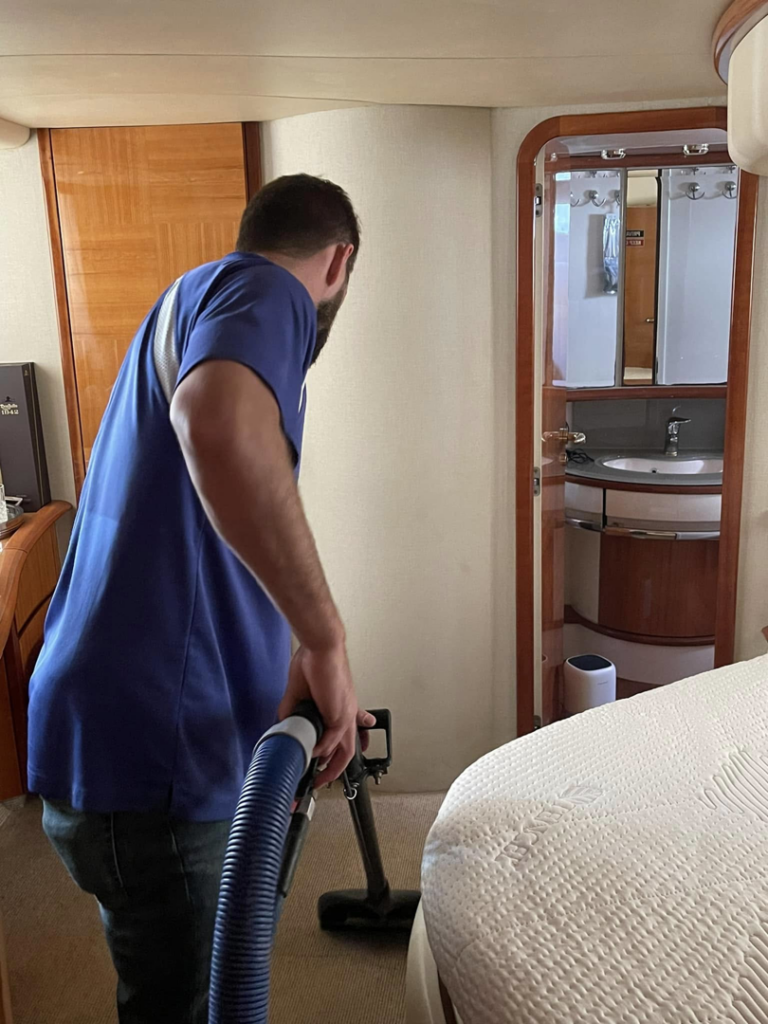 A Service Kings Home Services technician cleaning carpet in a yacht cabin in San Diego, CA.