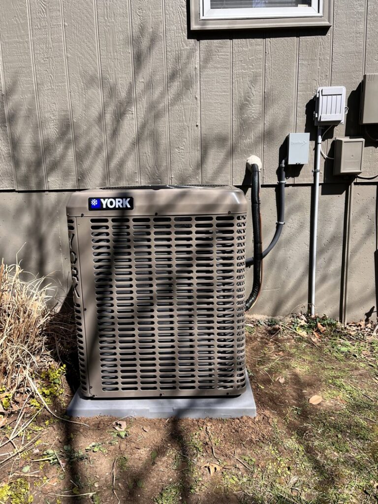 A newly installed York AC condenser unit outside a home by Pronto Air, an HVAC contractor in Olathe, KS.
