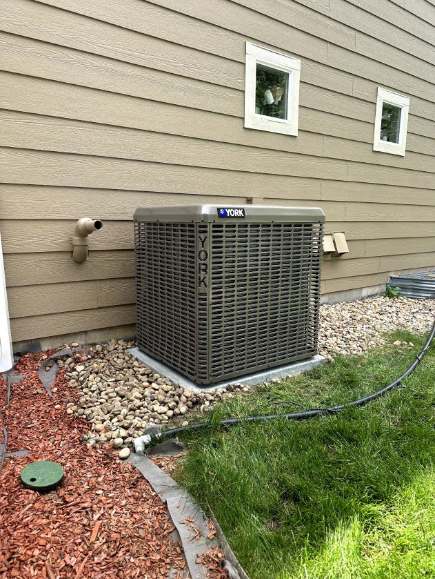 A York air conditioner condenser unit installed outside a home by Husky Heating and Cooling in Westminster, CO.