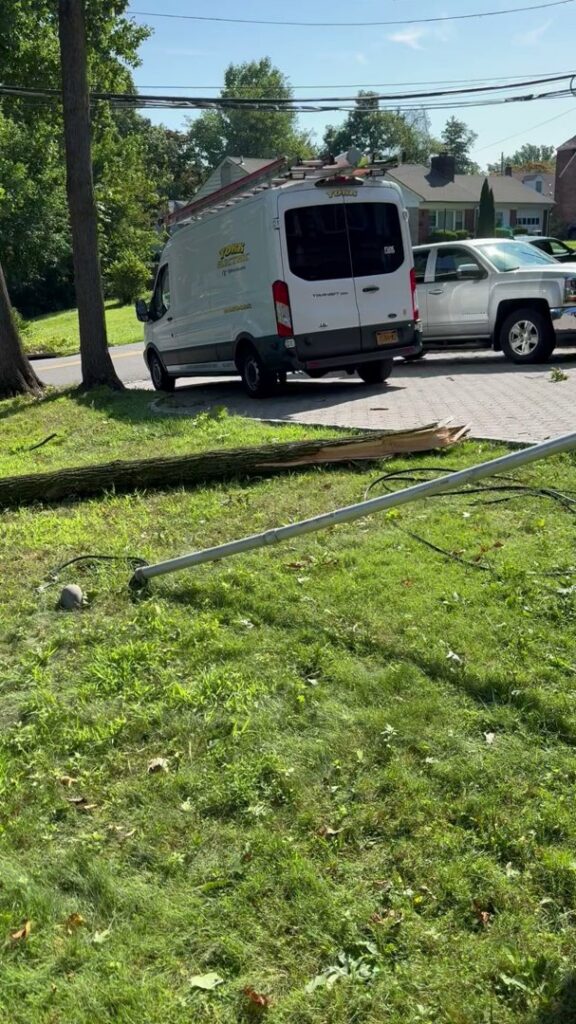 A York Electric of Westchester van at a site with a fallen utility pole or tree branch, indicating emergency electrical service in Yonkers, NY.