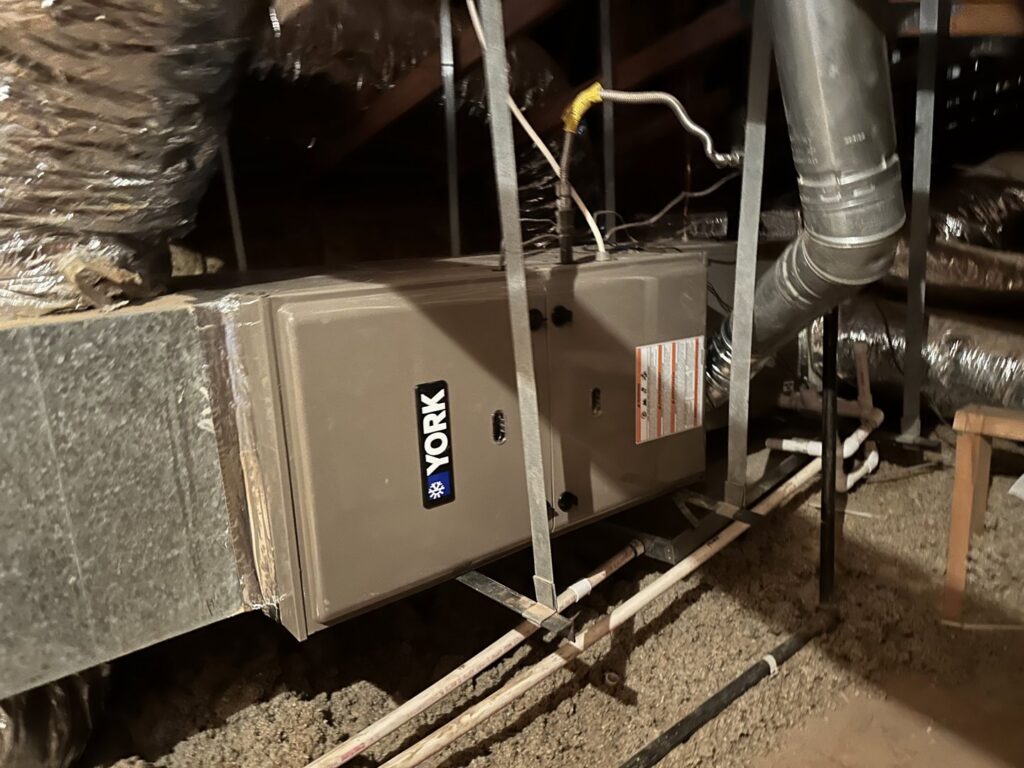 A new York furnace or air handler unit installed with ductwork in an attic by TK Heating and Air, PLLC in Queen Creek, AZ