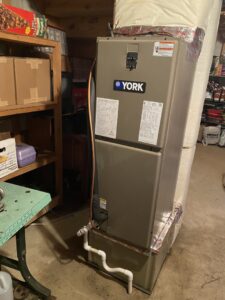 A York furnace and air handler unit with ductwork installed in a utility space by Grozier Heating and Air Conditioning, LLC in Allentown, PA.