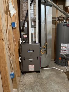 A YORK furnace unit and water heater installed in a utility room by 4-BIS Solutions HVAC and Home Maintenance in Columbia, MO.