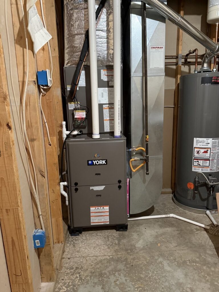 A YORK furnace unit and water heater installed in a utility room by 4-BIS Solutions HVAC and Home Maintenance in Columbia, MO.