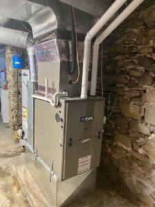 A York furnace and air handler unit installed in a stone basement by Grozier Heating and Air Conditioning, LLC in Allentown, PA.