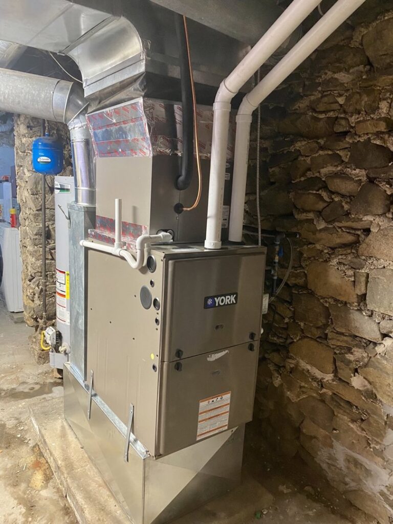 A York furnace and air handler unit installed in a stone basement by Grozier Heating and Air Conditioning, LLC in Allentown, PA.