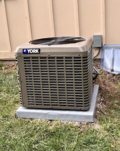 A new York outdoor AC condenser unit installed by Pronto Air, an HVAC contractor in Olathe, KS.