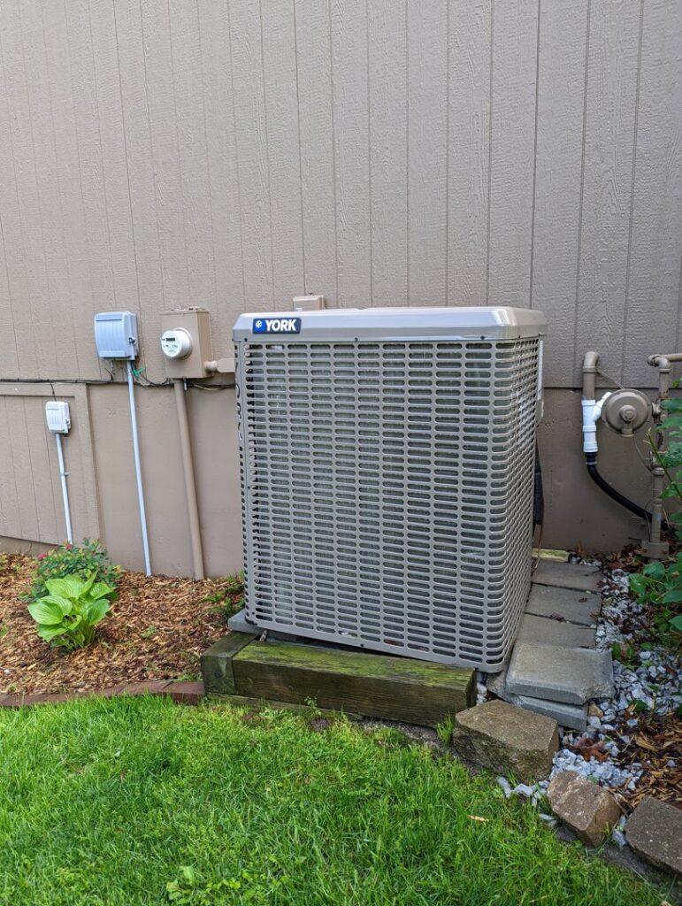A York outdoor air conditioning unit installed next to a residential building, serviced by TAS Mechanical Services in Kearney, MO.