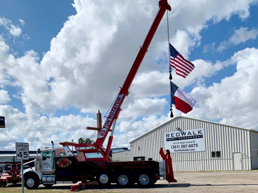 A powerful 65-ton rotator tow truck from CC Wrecker Service, displaying flags in Corpus Christi, TX.