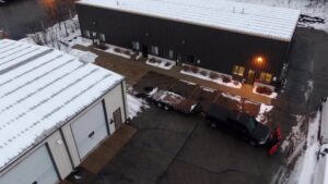 An aerial view of a commercial property with a truck and snow plow performing snow removal by Haynes Snow Removal & Lawn Maintenance in Madison, WI.